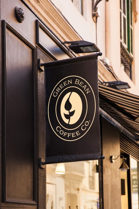 Schild der Green Bean Coffee Co. an einer Fassade, mit schwarzem Hintergrund und Logo.